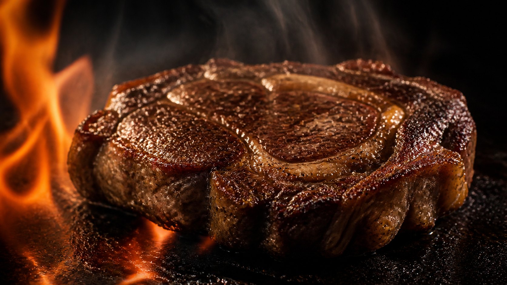 Ojo de bife sellándose sobre plancha de hierro con llamas de fondo